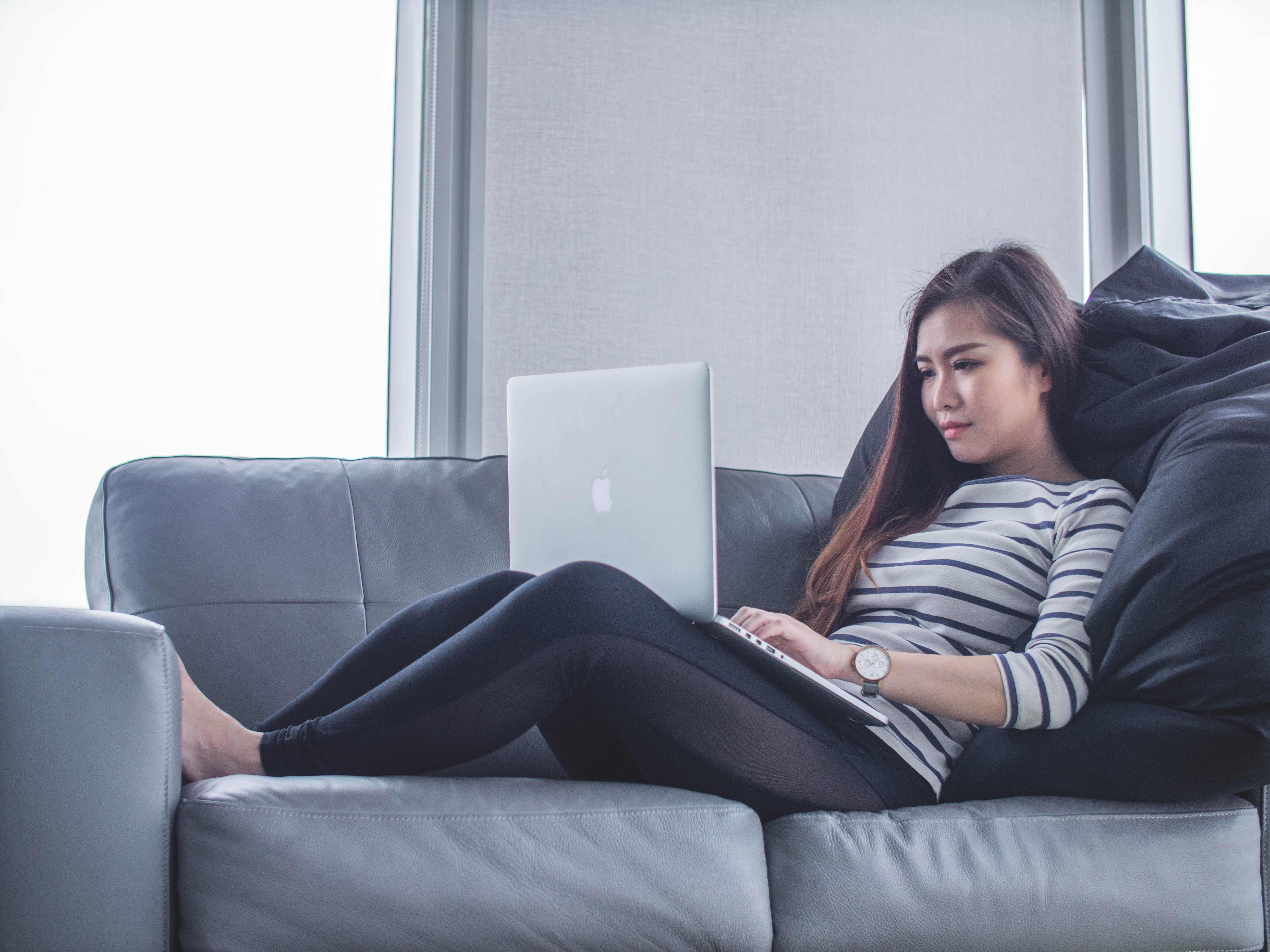 Allocloud VOIP BHC Une femme dasn un canapé sur son téléphone